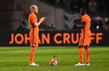 Netherland's midfielder Davy Klaassen (L) and Netherland's midfielder Quincy Promes applaud during a standing ovation in honour of late Dutch football legend Johann Cruyff during a pause in the 14th minute of the friendly football match between the Nether