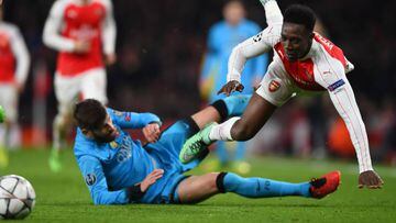 Danny Welbeck of Arsenal is fouled by Gerard Pique of Barcelona during the UEFA Champions League round of 16, first leg match between Arsenal FC and FC Barcelona at the Emirates Stadium.