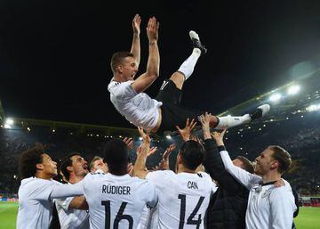 Lukas Podolski is thrown in the air by his team mates after playing his last game for Germany during the international friendly match