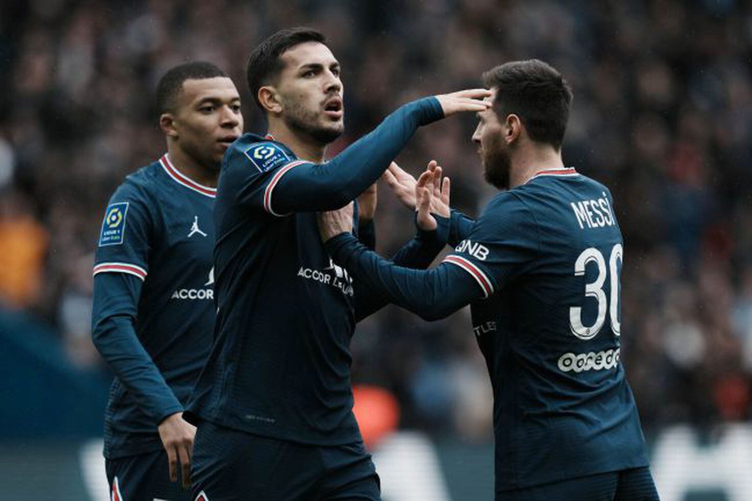 PSG's Leandro Paredes celebrates with his teammate Lionel Messi, right, and Kylian Mbappé, left, after scoring PSG's third goal against Bordeaux at the Parc des Princes stadium in Paris, France on Sunday 13 March 2022.