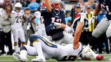 FOXBORO, MA - OCTOBER 29: Tom Brady #12 of the New England Patriots throws as he is tackled by Joey Bosa #99 of the Los Angeles Chargers during the second quarter of a game at Gillette Stadium on October 29, 2017 in Foxboro, Massachusetts.   Jim Rogash/Getty Images/AFP == FOR NEWSPAPERS, INTERNET, TELCOS &amp; TELEVISION USE ONLY ==