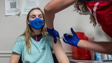 (FILES) In this file photo Audrey Vakker, 14, looks on as she get a Covid-19 vaccination at the Fairfax Government Center vaccination clinic in Fairfax, Virginia on May 13, 2021. - US health authorities said they were looking into a small number of report