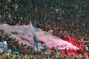 SSc Napoli fans burn flares and hold a giant banner with the symbol of the UEFA Champions League at the end of the Italian Serie A football match
