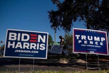 Biden and Trump campaign signs are displayed as voters line-up to cast their ballots during early voting at the Alafaya Branch Library in Orlando, Florida.