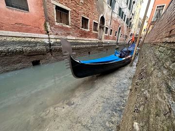Una góndola en un canal seco durante la marea baja en la ciudad laguna de Venecia, Italia.