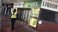 A security guard stands outside a liquor store closed under the coronavirus disease (COVID-19) lockdown regulations that prohibit alcohol sales in Cape Town, South Africa, August 13, 2020. Picture taken August 13, 2020. REUTERS/Mike Hutchings