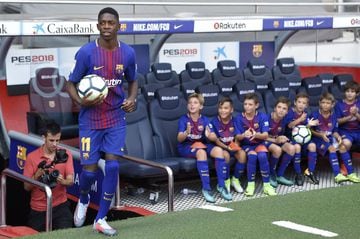 Barcelona's new player Ousmane Dembele (L) enters the pitch past young fans at the Camp Nou stadium in Barcelona, during his official presentation by the Catalan football club, on August 28, 2017.