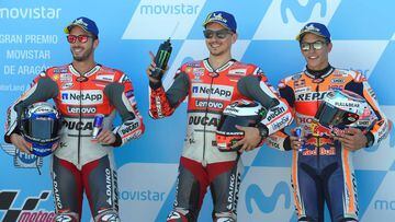 Ducati Team&#039;s Spanish rider Jorge Lorenzo (C) celebrates getting the &#039;pole&#039; position after being first in the MotoGP qualifier of the Aragon Grand Prix, beside second placed Ducati Team&#039;s Italian rider Andrea Dovizioso (L) and third Re