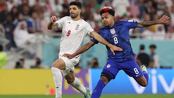 Iran's forward #09 Mehdi Taremi (L) fights for the ball with USA's midfielder #08 Weston McKennie during the Qatar 2022 World Cup Group B football match between Iran and USA at the Al-Thumama Stadium in Doha on November 29, 2022. (Photo by Fadel Senna / AFP)