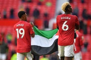 Manchester United's Ivorian midfielder Amad Diallo (L) and Manchester United's French midfielder Paul Pogba (R) walk around the pitch at the end of the game during the English Premier League football match between Manchester United and Fulham at Old Traff