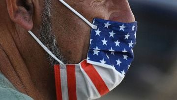 A man wears an American flag face mask on  a street in Hollywood, California, on the second day of the return of the indoor mask mandate in Los Angeles County.