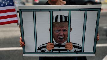 A demonstrator holds a sign of former U.S. President Donald Trump behind bars outside a courthouse in New York City, U.S., September 22, 2023.  REUTERS/Shannon Stapleton