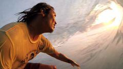 Mikala Jones grab&aacute;ndose mientras surfea al atardecer un tubo en indonesia. 