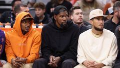 PHOENIX, ARIZONA - OCTOBER 10: (L-R) Bradley Beal #3, Kevin Durant #35 and Devin Booker #1 of the Phoenix Suns watch from the bench during the second half of the NBA game against the Denver Nuggets at Footprint Center on October 10, 2023 in Phoenix, Arizona.   Christian Petersen/Getty Images/AFP (Photo by Christian Petersen / GETTY IMAGES NORTH AMERICA / Getty Images via AFP)