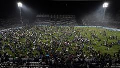 Fans of Gimnasia y Esgrima La Plata affected by tear gas invade the field after the match between Gimnasia y Esgrima La Plata and Boca Juniors in the Liga Profesional 2022 was suspended due clashes between supporters and the police outside the stadium, at Juan Carmelo Zerillo Stadium, in La Plata, Argentina October 6, 2022. REUTERS/Jose Brusco NO RESALES. NO ARCHIVES.