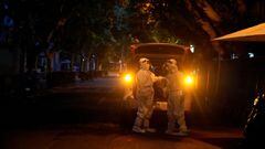 Workers in protective suits stand in a closed street during lockdown, amid the coronavirus disease (COVID-19) pandemic, in Shanghai, China, May 19, 2022. REUTERS/Aly Song