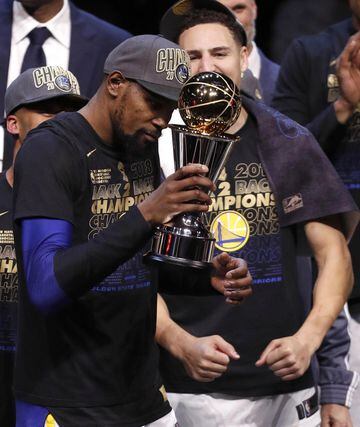 Kevin Durant con el trofeo Larry O'Brien y con el trofeo Bill Russell que le acredita como MVP de las Finales.