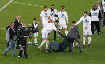 A pitch invader is apprehended as he approaches Real Madrid’s Cristiano Ronaldo after the game