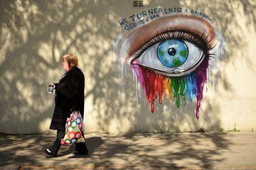 A woman walks past a graffiti mural by street artist Rachel List paying tribute to Britain's NHS (National Health Service) staff battling the COVID-19 outbreak, on a wall in Pontefract, northern England, on April 27, 2020