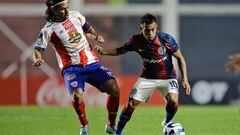Estudiantes de Merida's midfielder Jesus Gomez (L) and San Lorenzo's forward Cristian Barrios fight for the ball during the Copa Sudamericana group stage second leg football match between Argentina's San Lorenzo and Venezuela's Estudiantes de Merida, at the Pedro Bidegain stadium in Buenos Aires, on June 27, 2023. (Photo by Emiliano Lasalvia / AFP)