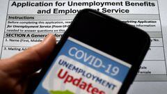 (FILES) In this file photo illustration, a COVID-19 Unemployment Assistance Updates logo is displayed on a smartphone on top of an application for unemployment benefits on May 8, 2020, in Arlington, Virginia. - US consumer confidence deteriorated in July 