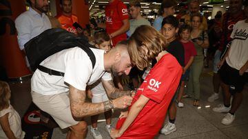 Sergi Darder firma una camiseta mallorquinista en su llegada al aeropuerto de Palma