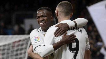 Vinicius and Benzema share an embrace.