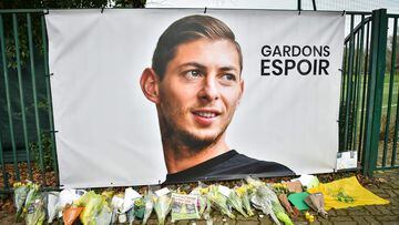 (FILES) In this file photo taken on January 24, 2019 flowers are laid under a portrait of Argentinian forward Emiliano Sala at the FC Nantes training centre La Joneliere in La Chapelle-sur-Erdre, western France. - Sala felt under "a lot of pressure" to complete a transfer to the Premier League shortly before he died in a plane crash as he headed to his new club, an inquest heard on February 15, 2022. (Photo by LOIC VENANCE / AFP)