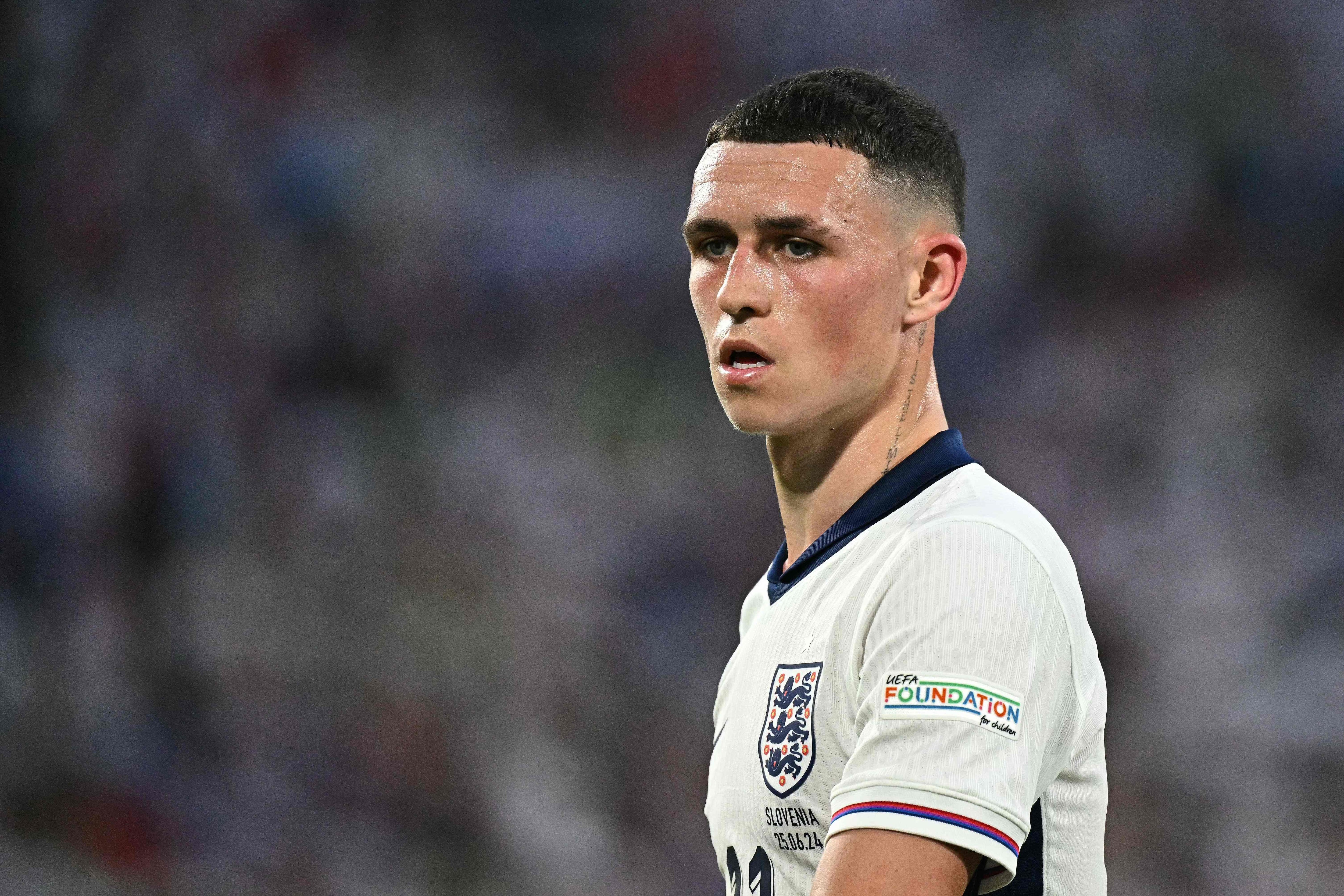 (FILES) England's midfielder #11 Phil Foden looks on during the UEFA Euro 2024 Group C football match between England and Slovenia at the Cologne Stadium in Cologne on June 25, 2024. Phil Foden has temporarily left England's Euro 2024 base in Germany to return home due to a "pressing family matter," the English Football Association announced on June 26, 2024. (Photo by JAVIER SORIANO / AFP)