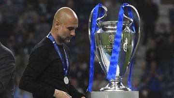 Manchester City head coach Pep Guardiola walks past the Champions League trophy after his team's 1-0 defeat to Chelsea in the 2021 final.