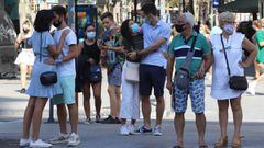 Imagen de varias parejas transitando una de las calles de Barcelona con mascarillas.
