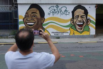 Un hombre en Sao Paulo hace una foto a un mural con las dos grandes estrellas del fútbol brasileño, Garrincha y Pelé.