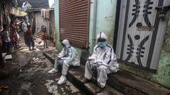 Mumbai (India), 07/07/2020.- Indian health workers wearing personal protective equipment (PPE) sit on the staircase as they rest from exhaustion during conducting medical checkup of the residents of a &#039;containment zones&#039; in Ambujwadi area, a COV