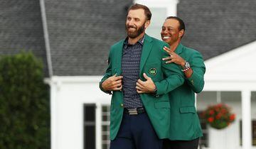 El golfista estadounidense Dustin Johnson recibe por parte de Tiger Woods la chaqueta verde del campeón del Masters de Augusta.