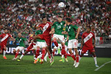 Peru's midfielder Renato Tapia (L) and Mexico's forward Santiago Gimenez (C) vie for the ball during the international friendly football match between Mexico and Peru at the Rose Bowl in Pasadena, California, on September 24, 2022. (Photo by Robyn Beck / AFP)