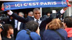 Paris Saint-Germain's new forward Kylian Mbappe stands next to his brother Ethan (L) as he holds a PSG fan scarf during his presentation at the Parc des Princes stadium in Paris on September 6, 2017./ FRANCK FIFE