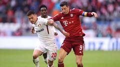 MUNICH, GERMANY - MARCH 05: Robert Lewandowsk of Bayern Munchen tackles with Charles Aranguiz of Leverkusen  during the Bundesliga match between FC Bayern München and Bayer 04 Leverkusen at Allianz Arena on March 05, 2022 in Munich, Germany. (Photo by Alex Grimm/Getty Images)