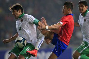 Alexis Sánchez lucha la pelota ante un jugador de Bolivia.