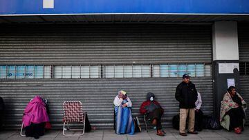 People line up outside a bank in the municipality of Jose C Paz, province of Buenos Aires, on April 4, 2020 during the lockdown in Argentina to slow the spread of the novel coronavirus COVID-19. - Long queues of retirees and social security beneficiaries lined up on Saturday again in front of banks in Argentina, on the second day of exclusive public attention since the mandatory social isolation was decreed on March 20 due to the new coronavirus. (Photo by Ronaldo SCHEMIDT / AFP)