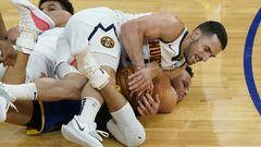 Denver Nuggets guard Facundo Campazzo, top, reaches for the ball over Golden State Warriors guard Stephen Curry during the second half of an NBA basketball game in San Francisco, Monday, April 12, 2021. (AP Photo/Jeff Chiu)