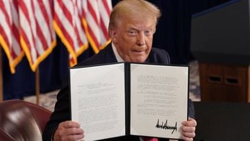 U.S. President Donald Trump shows signed executive orders for economic relief during a news conference amid the spread of the coronavirus disease (COVID-19), at his golf resort in Bedminster, New Jersey, U.S., August 8, 2020. REUTERS/Joshua Roberts