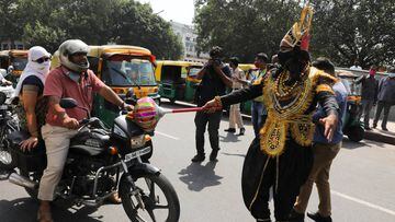 A volunteer of District Magistrate (DM) office dressed as Yamraj, or Hindu God of death, stops people for not wearing masks, amidst the spread of the coronavirus(COVID-19) disease, in New Delhi, India, September 28, 2020. REUTERS/Anushree Fadnavis