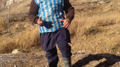 This photograph taken on January 24, 2016 and provided by the family of Afghan boy and Lionel Messi fan Murtaza Ahmadi, 5, shows him wearing a plastic bag jersey as he plays football in Jaghori district of Ghazni province.