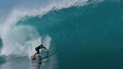 Craig Anderson a punto de meterse en una ola en forma de tubo con su tabla de surf para el videoclip Slidin de Paul McCartney. 