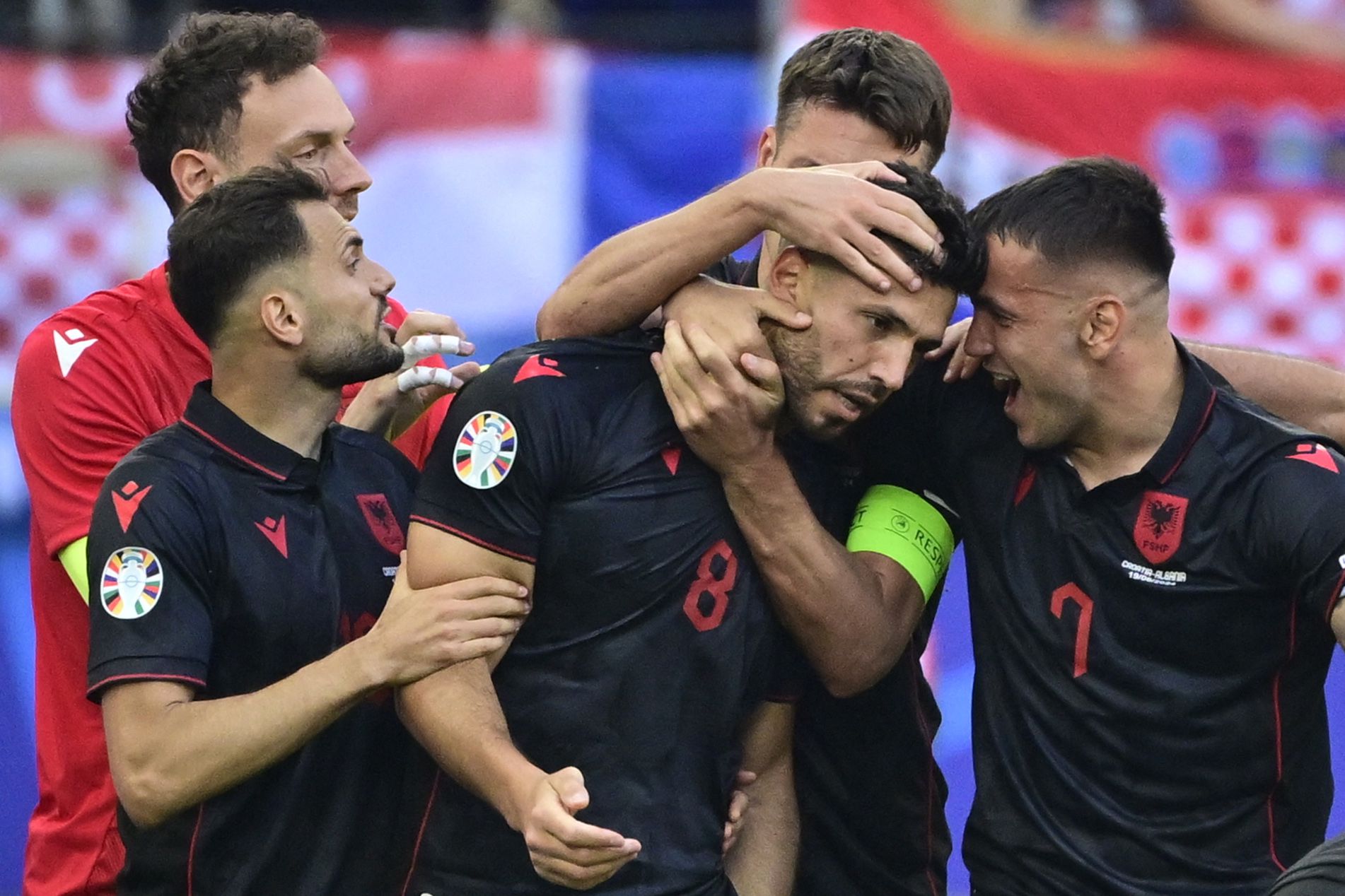 Albania's midfielder #08 Klaus Gjasula celebrates with his team mates after scoring the equalising goal 2:2 during the UEFA Euro 2024 Group B football match between Croatia and Albania at the Volksparkstadion in Hamburg on June 19, 2024. (Photo by JOHN MACDOUGALL / AFP)