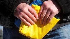 A man holds the national flag of Ukraine.