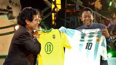 Former Argentine soccer star Diego Maradona (L) and Brazilian soccer legend Pele exchange jerseys of their former national teams during the first edition of Maradona's show "La Noche del Diez" (The Night of Number 10), aired by Channel 13, in Buenos Aires August 15, 2005. Italian actress Maria Grazia Cucinotta and ex-Argentine soccer player Gabriel Batistuta were also guests of honor in the new television program. EDITORIAL USE ONLY NO SALES REUTERS/Prensa Canal 13/Handout