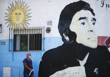 A man walks past a mural of Diego Maradona at Paternal neighbourhood near Argentinos Juniors Club in Buenos Aires