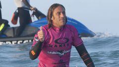 Jaco Rodr&iacute;guez levantando el pular, con licra rosa y sobre su tabla de surf, durante la edici&oacute;n de La Vaca Gigante 2016 celebrada en Santander, Cantabria, con el jet ski de rescate al fondo. 