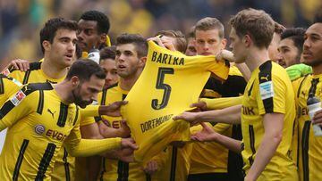 Dortmund&#039;s players hold the jersey of Dortmund&#039;s Spanish defender Marc Bartra who was injured during the bus attack on April 11 